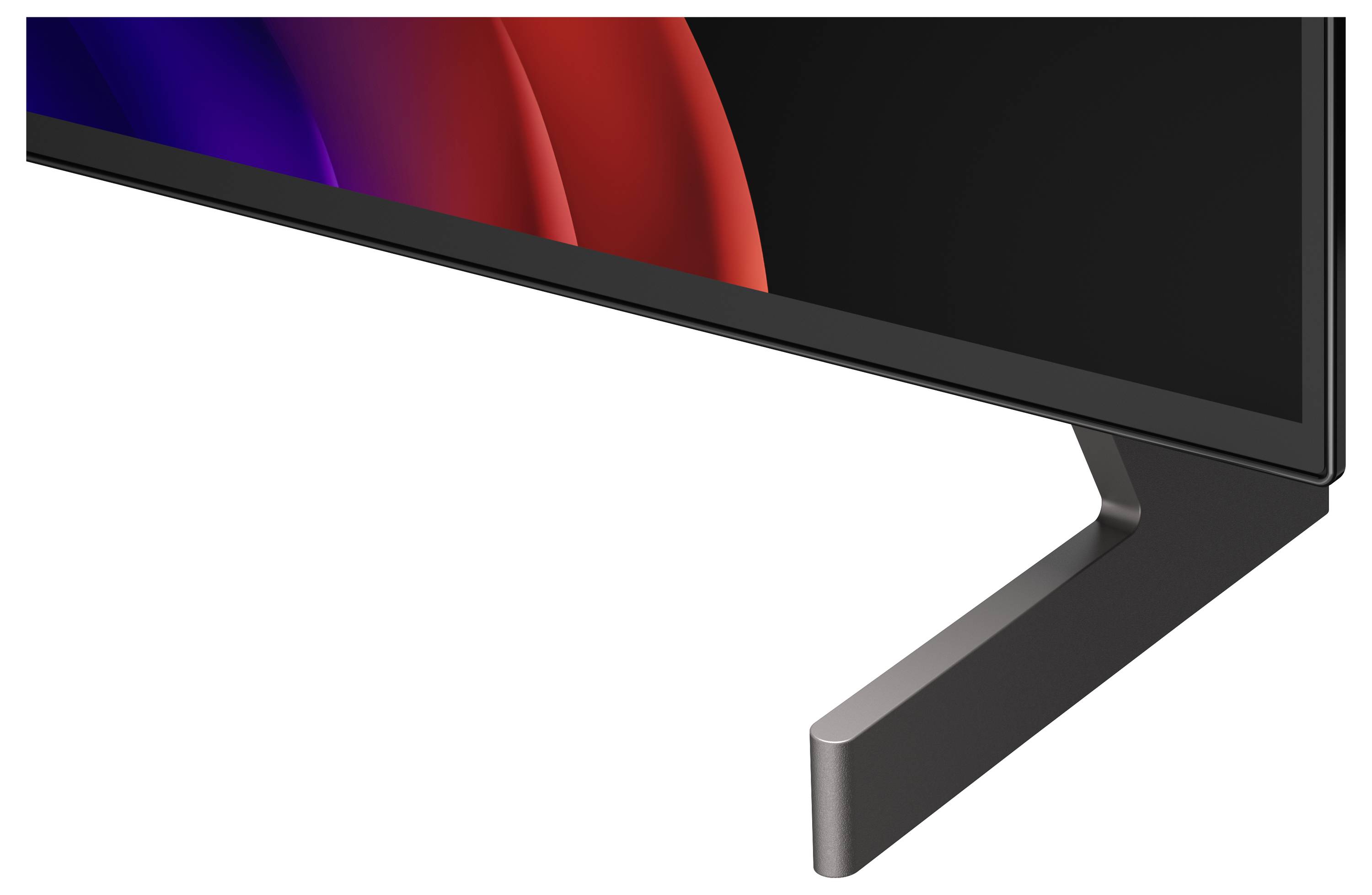 Detailní snímek dolního pravého rohu plochého monitoru a stojanu, zobrazující tenký černý rámeček a zakřivěnou tmavě šedou oporu na bílém pozadí.