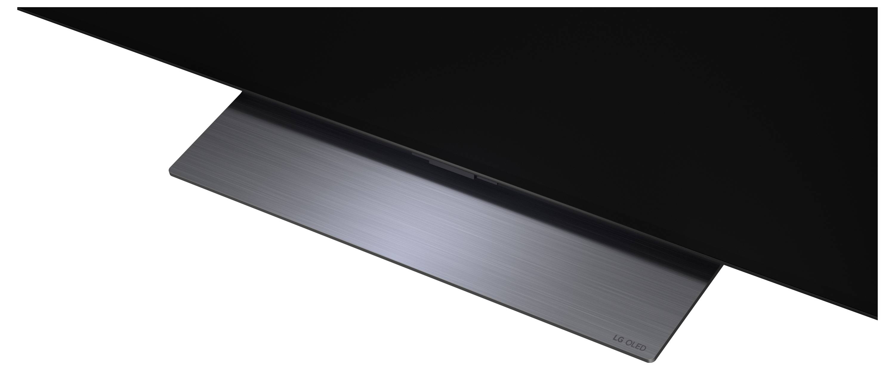 Moderní kovový laptop částečně otevřený pod černým trojúhelníkovým krytem, zobrazený v elegantním obrázku ve stylu produktové fotografie.