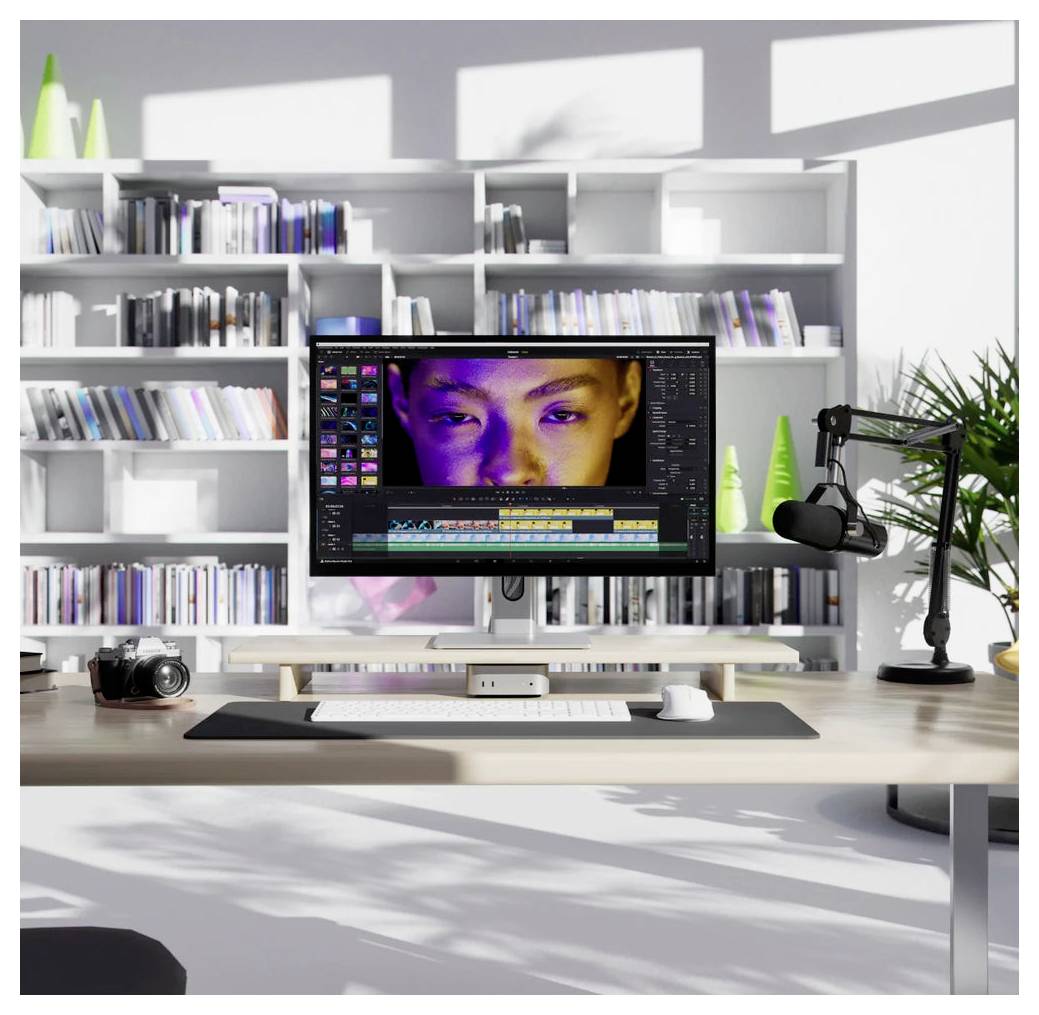 Moderní střižna s monitorem zobrazujícím software pro střihání videa a zblízka na obličej na časové ose, plus fotoaparát a mikrofon v jasné kancelářské studiu.