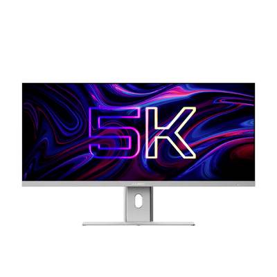 Plochý monitor zobrazující barevnou grafiku '5K' na černém abstraktním pozadí, umístěný na stojanu na bílém pozadí.