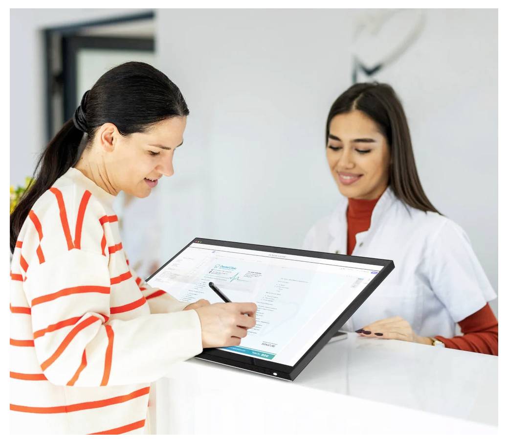 Žena podepisuje dokument na digitálním tabletu, zatímco se usměvavá recepční v bílém plášti pomáhá u přepážky služeb.