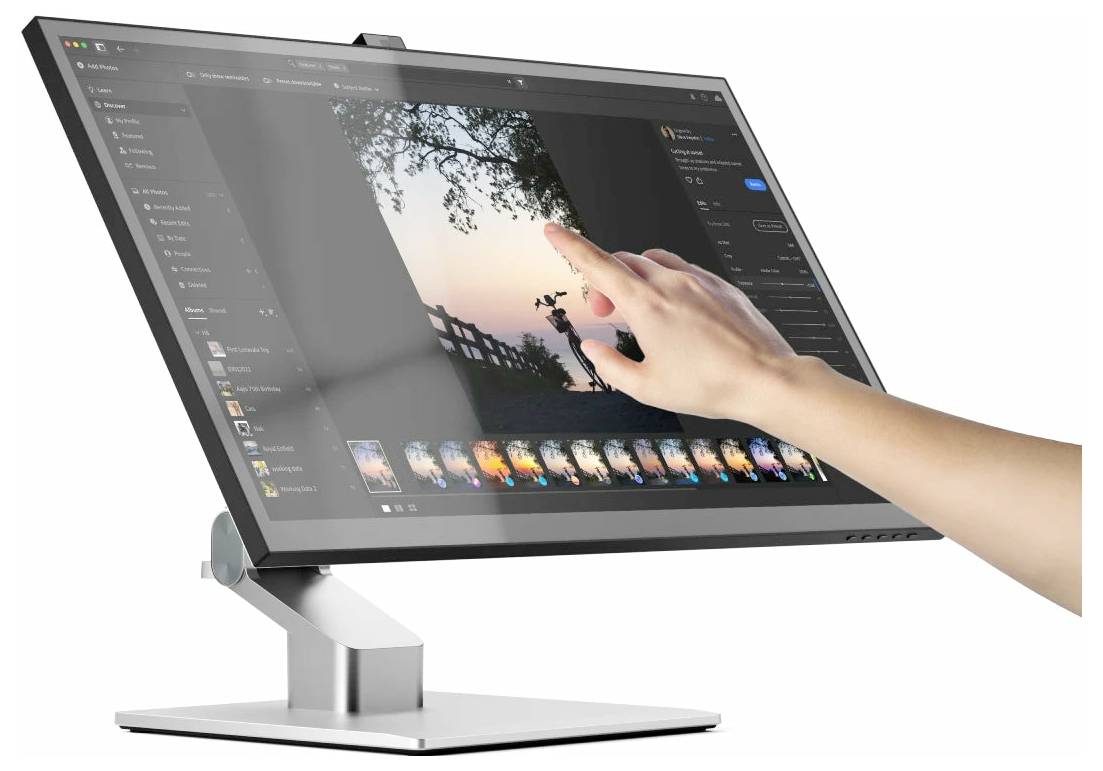 Osoba používá dotykový monitor k úpravě fotografie západu slunce v tmavě motivovaném editoru obrázků s miniaturami a panely nástrojů.