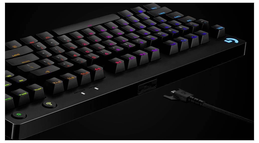 RGB podsvětlená mechanická herní klávesnice na černém povrchu, zobrazená v úhlu s připojeným USB kabelem.