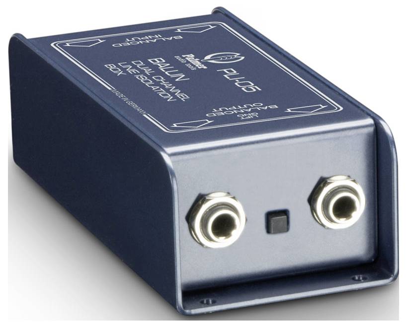 Kompaktní audio box označená "BALUN" se dvěma předními konektory a malým čtvercovým tlačítkem, zobrazená na bílém pozadí.