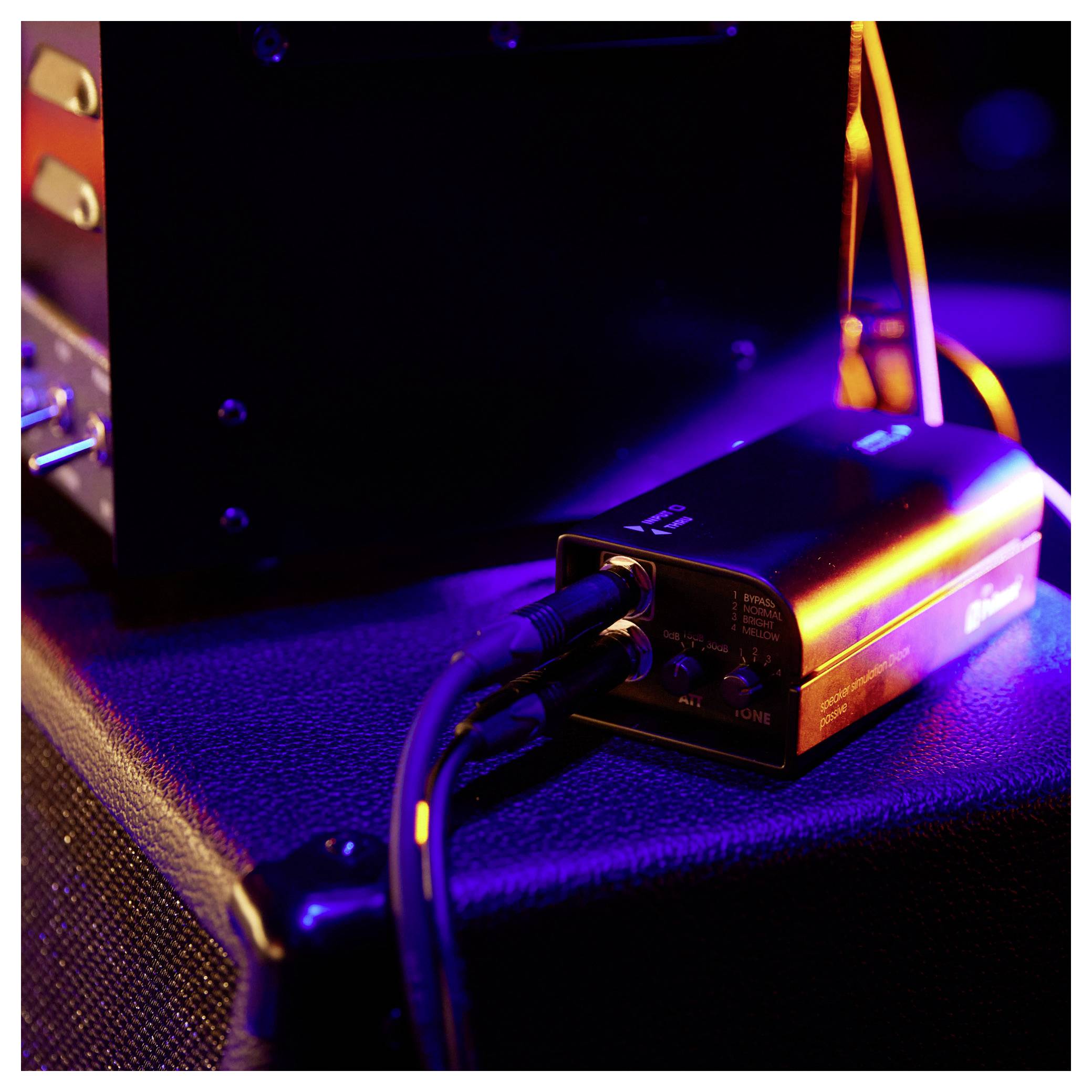 Black Palmer 'two channel line merger passive' audio device s oranžovým indikačním pruhem a popisky vstupů/výstupů na horní straně.