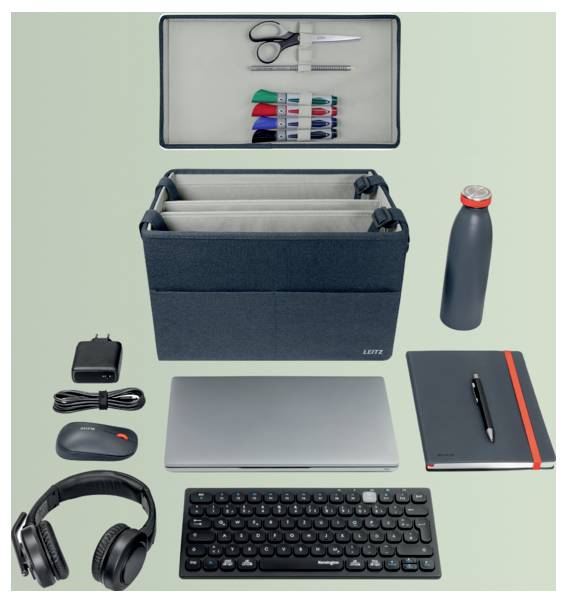 Pracovní vybavení rozložené do plochého záběru: organizační zásuvka s nůžkami a značkovači, taška na notebook, lahev na vodu, nabíječka, myš, sluchátka, sešit, pero a klávesnice.