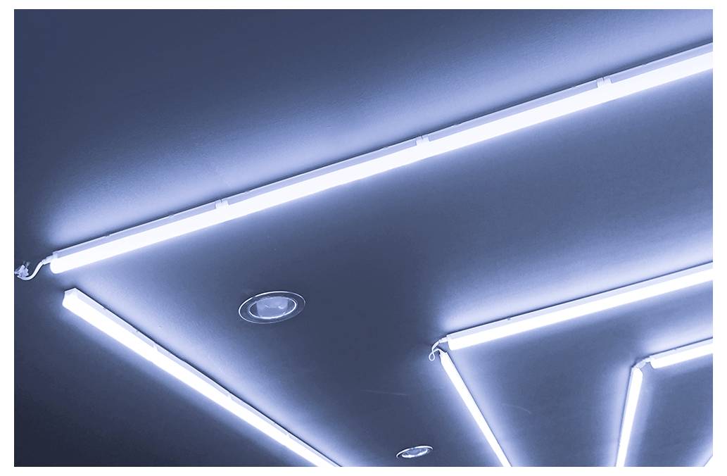 Geometrické LED stropní svítidla tvořící jasné úhlové čáry proti tmavému stropu
