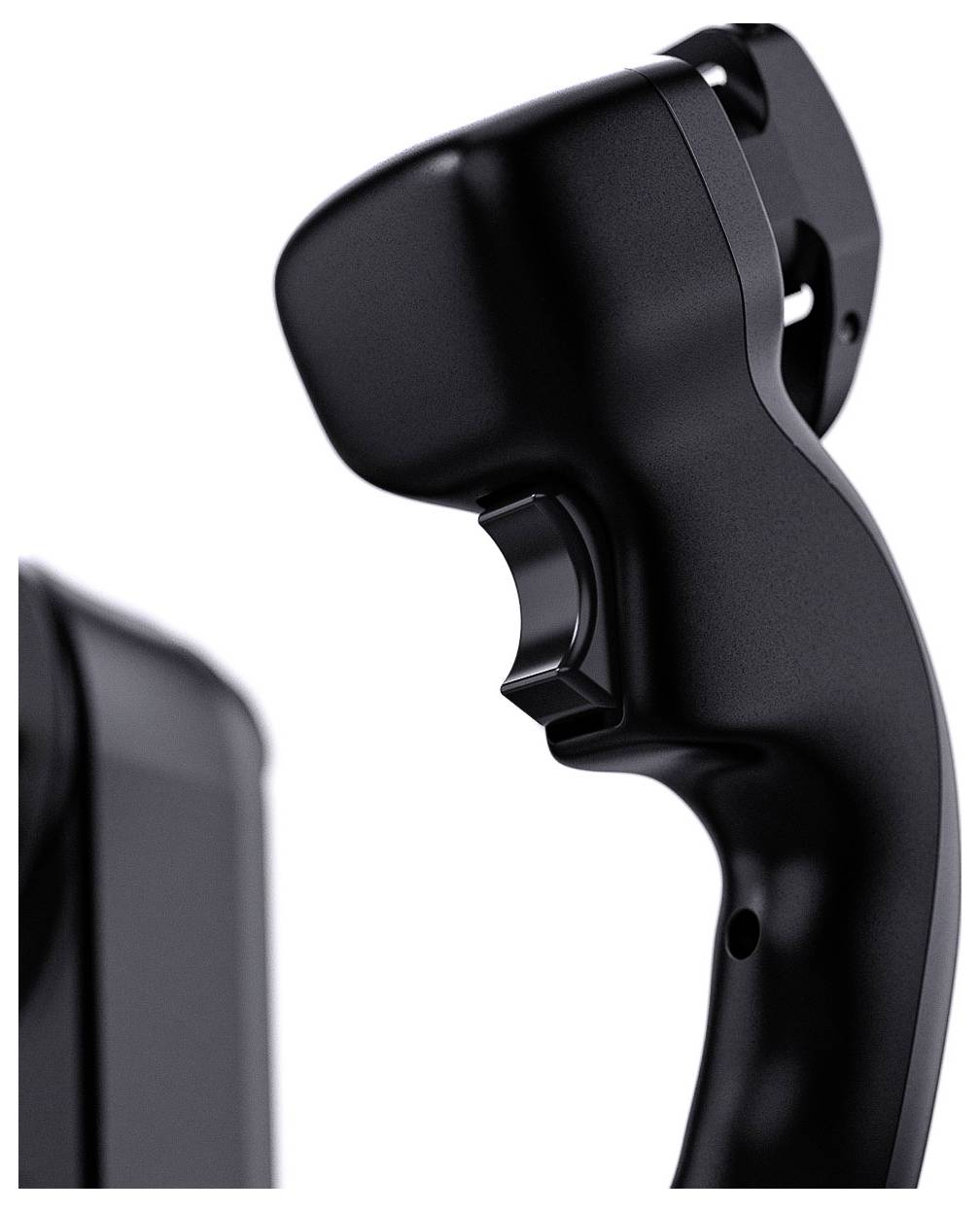 Detailní záběr na černý ergonomický rukojeť ve stylu joysticku nebo úchyt ovladače na bílém pozadí s rozmazaným okrajem zařízení vlevo.