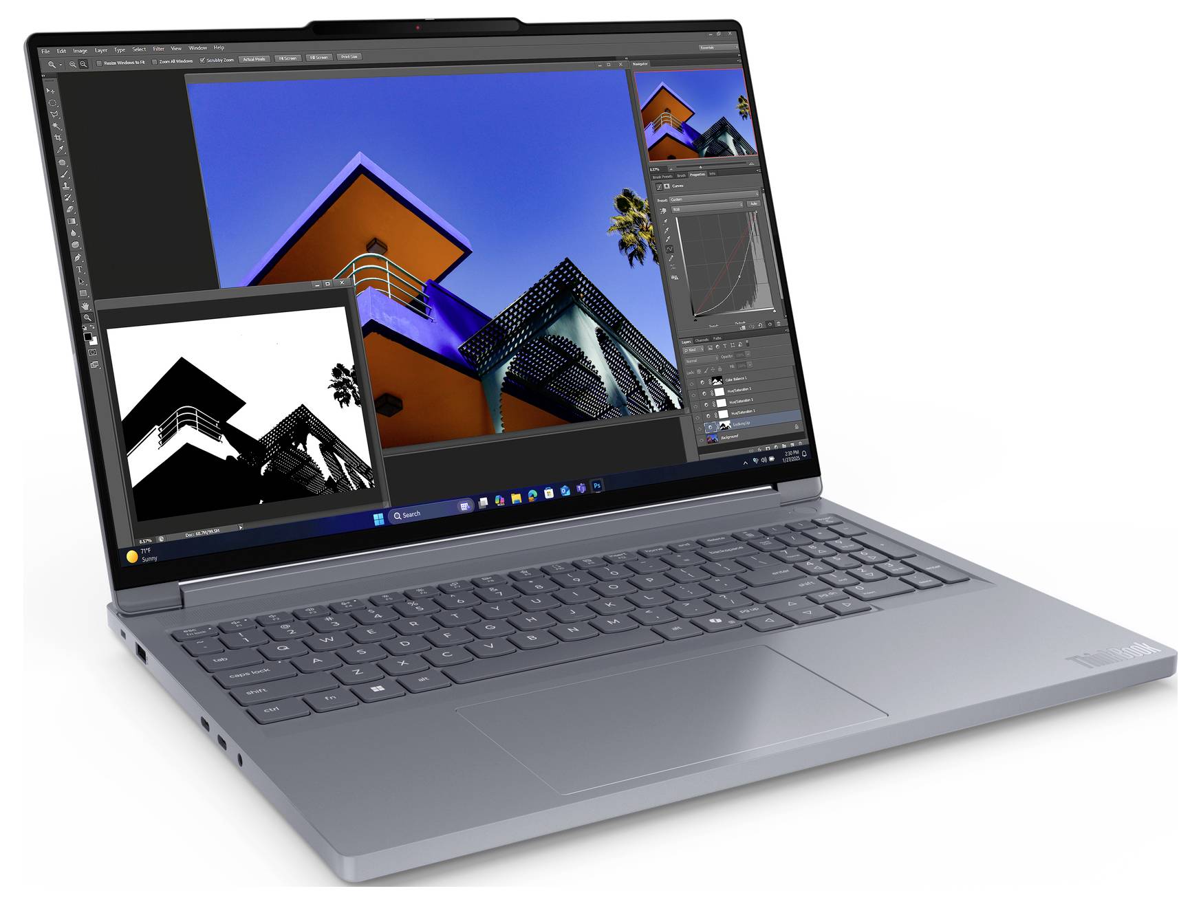 Stříbrný laptop zobrazující software pro úpravu fotografií s pestrobarevným obrázkem budovy a náhledem v černé a bílé barvě vloženým na obrazovce.