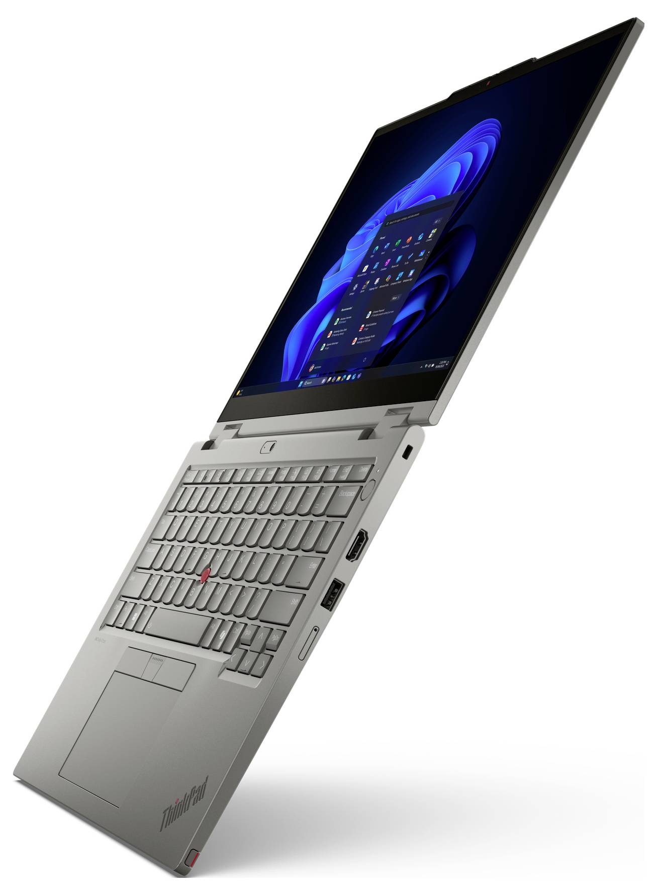 Nakloněný stříbrný laptop Lenovo ThinkPad s vysokou obrazovkou otevřenou na bílém pozadí, zobrazující plochu Windows.