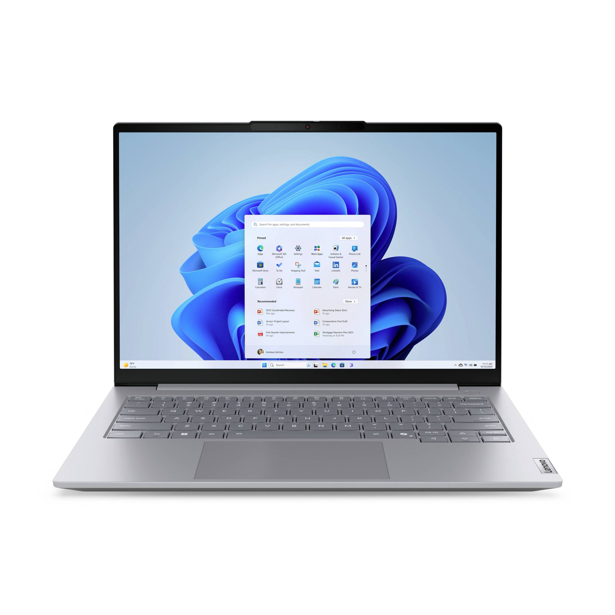 Stříbrný laptop zobrazující plochu Windows 11 s otevřenou nabídkou Start na modrém abstraktním pozadí.