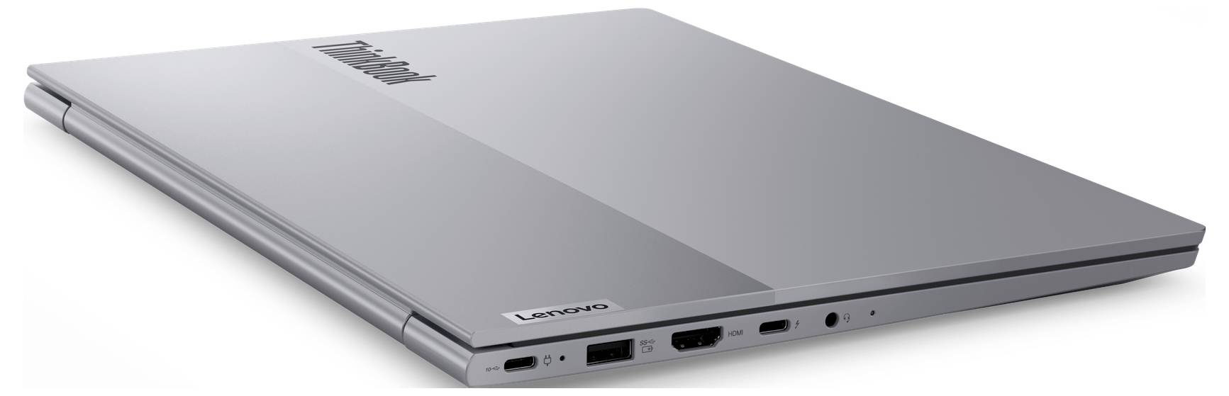 Uzavřený stříbrný Lenovo notebook zobrazený v úhlu, který zdůrazňuje elegantní tenký design a porty na přední straně.