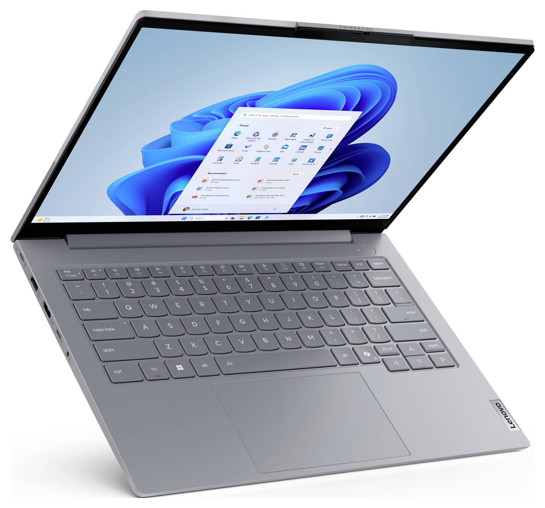 Šedý notebook Lenovo otevřený v úhlu, zobrazující plochu Windows 11 na obrazovce.