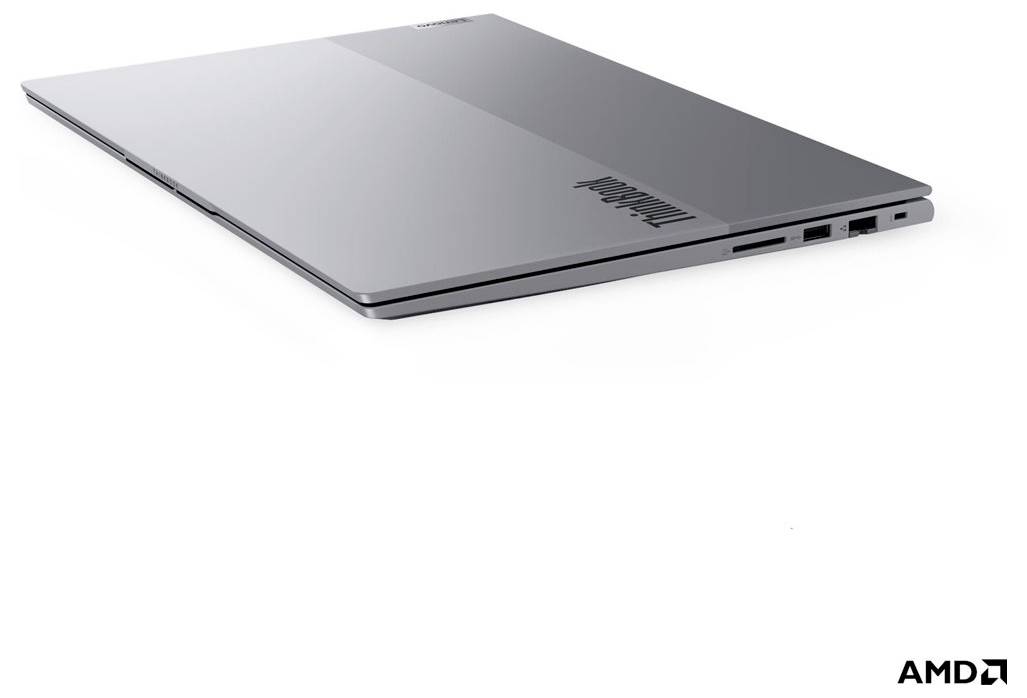 Stříbrný laptop Lenovo zobrazený zavřený v pohledu z tří čtvrtin shora, s viditelnými bočními porty a logem AMD v pravém dolním rohu.