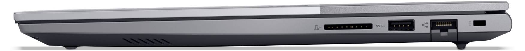 Boční pohled na zavřený stříbrný laptop zobrazující tenký profil, otvory pro větrání a porty podél zadního okraje.