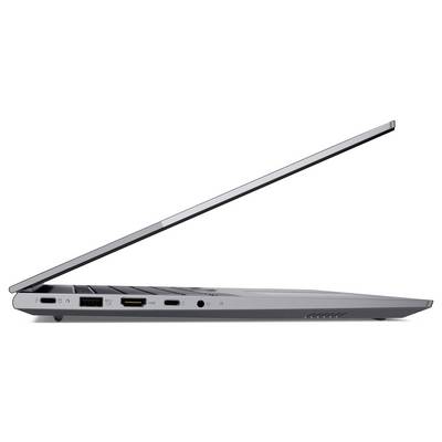 Boční pohled na tenký notebook napůl otevřený, zobrazující jeho porty a klávesnicový panel na prostém bílém pozadí.