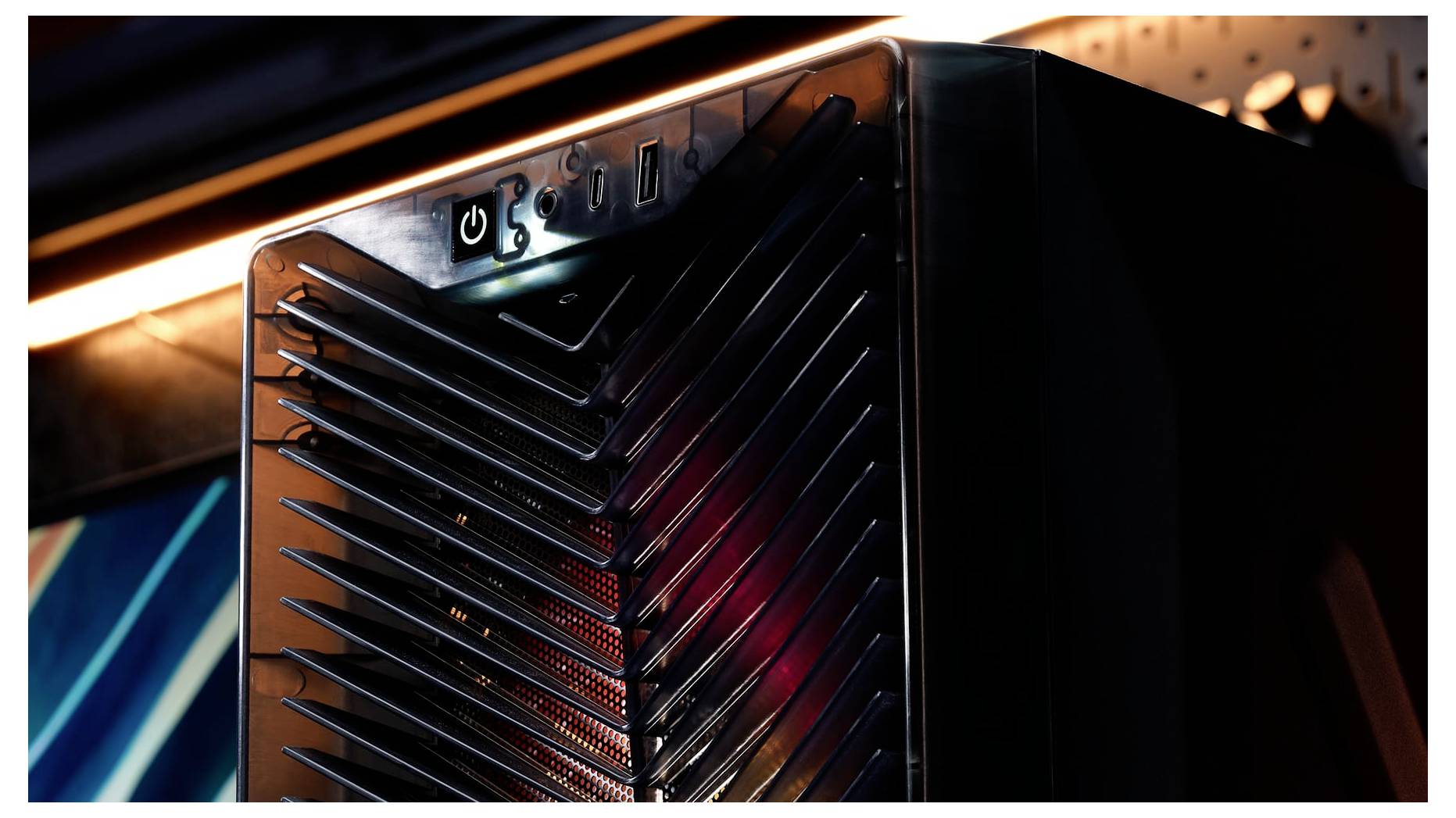 Detailní pohled na černou počítačovou věž nebo skříň serveru se zbarveným tlačítkem napájení a lamelovou přední deskou, zobrazeno v tlumavém nastavení.