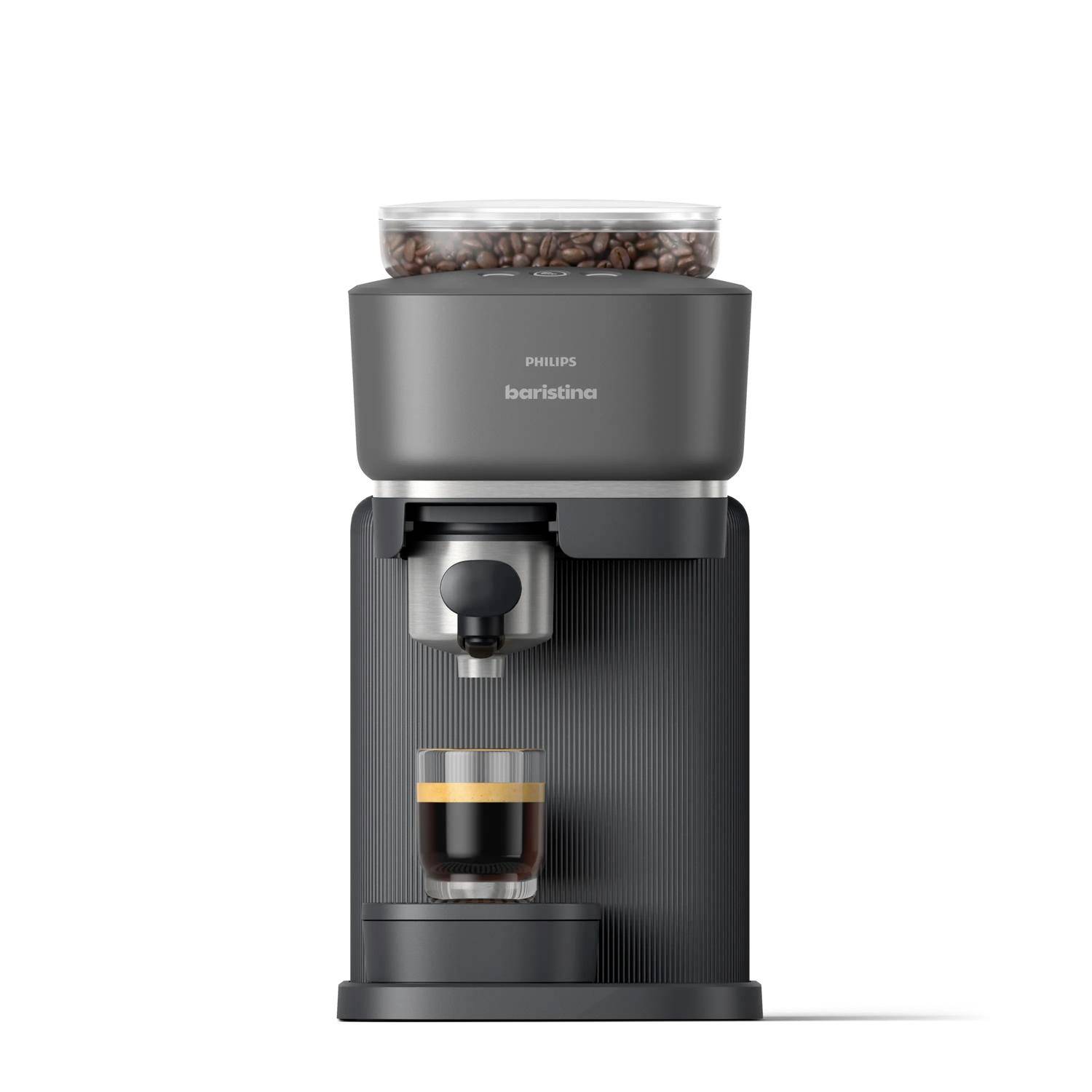 Přední pohled na kávovar Philips Baristina s zrny v zásobníku a sklenicí na espresso umístěnou pod výdejním otvorem.