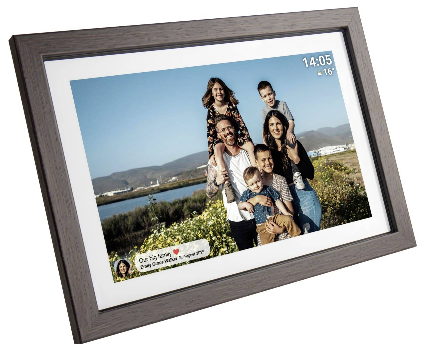 Digitální fotorámec zobrazující rodinný portrét venku s překrytím data a času v pravém horním rohu.