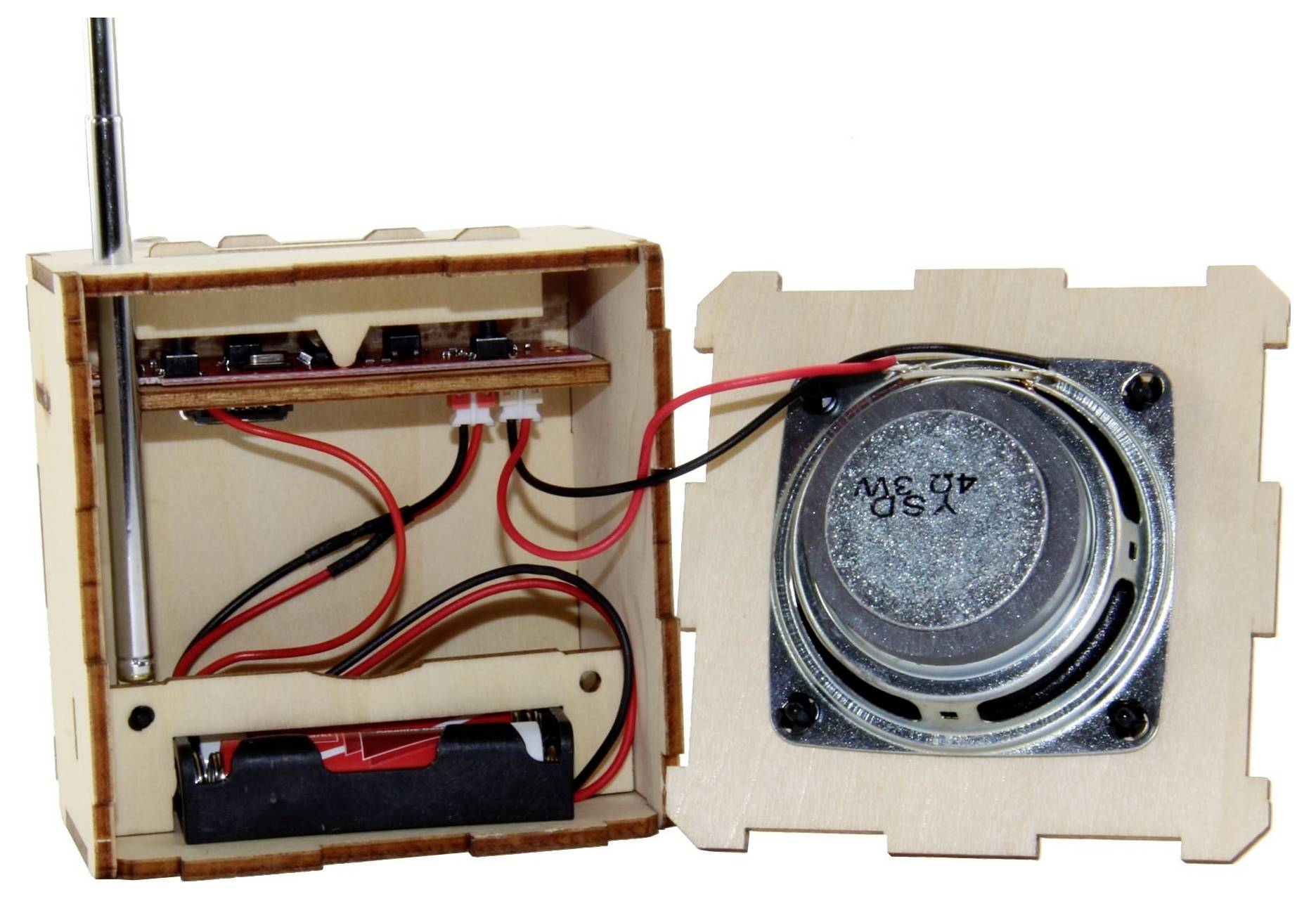 Otevřená dřevěná skříň elektroniky s kabeláží, bateriemi a reproduktorem namontovaným na víku; malý domácí projekt radia nebo audio zařízení.