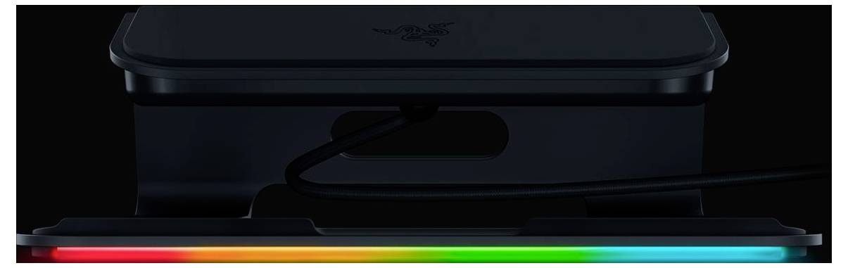 Detailní záběr na černé elektronické zařízení se svítícím RGB páskem podél spodní hrany a kabelem zapojeným do boku.