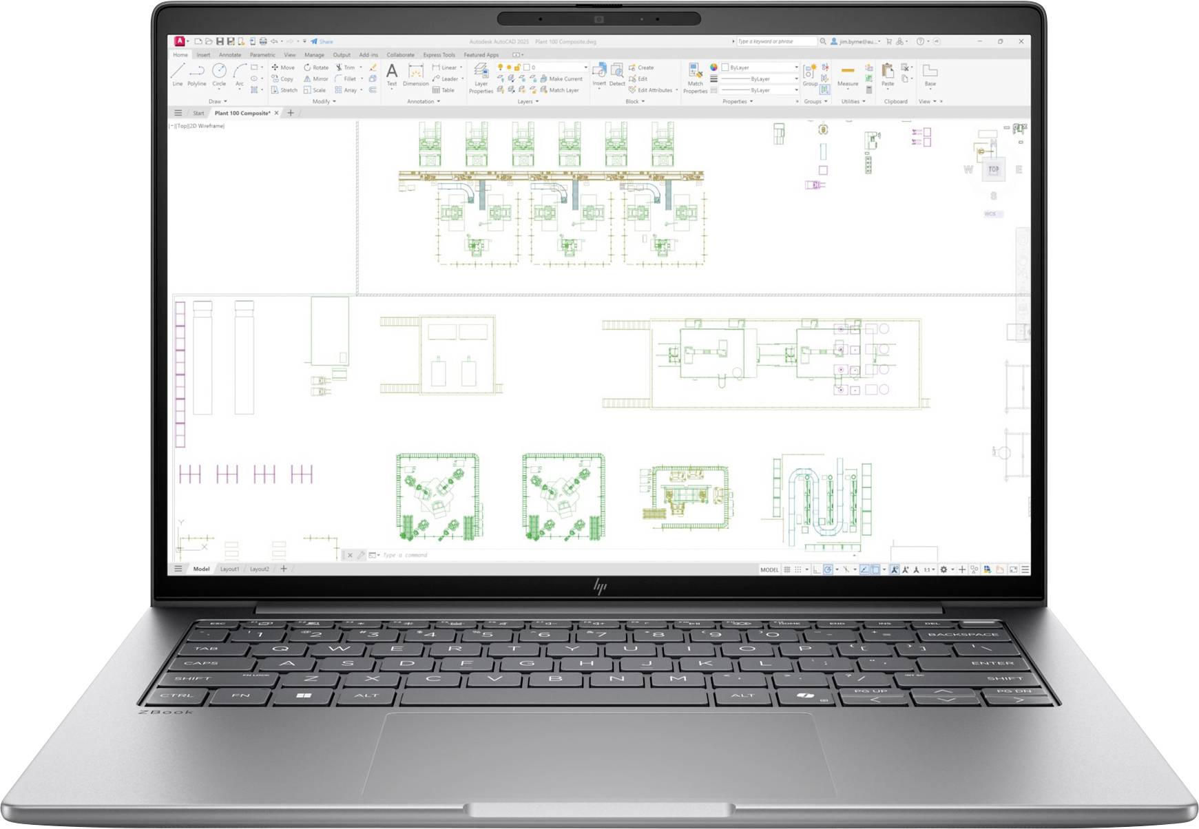Notebook s výkresom CAD/plánem podlahy zobrazujícím několik rozvržení místností a barevné architektonické symboly na pracovním prostoru návrhu.