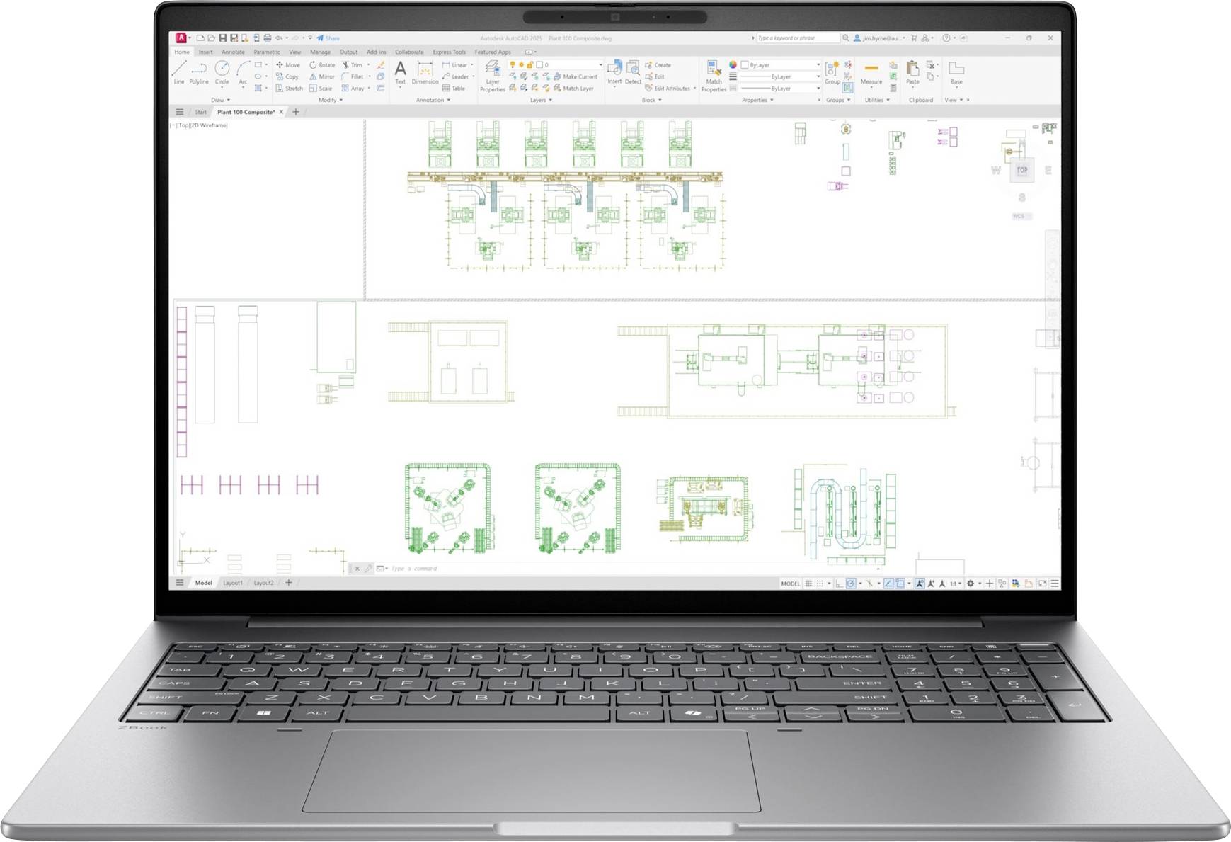 Přenosný počítač zobrazující CAD-stylový půdorys s více rozvrhy místností, symboly zařízení a poznámkami na bílém kreslicím plátně.