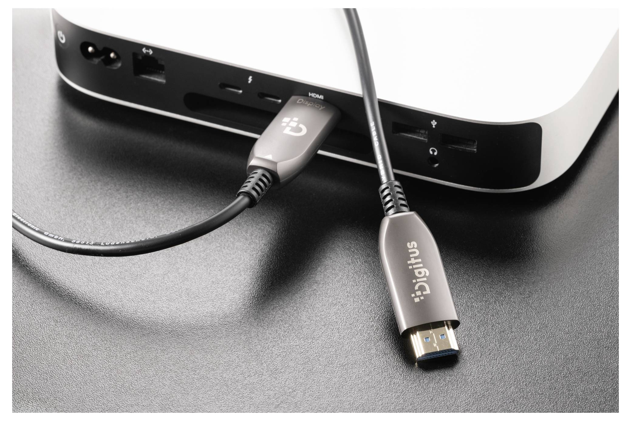 Dva kabely USB zapojené do předních portů zařízení, přičemž jeden je připojen k portu USB-C a jeden volný konektor USB-A s označením „bigius".