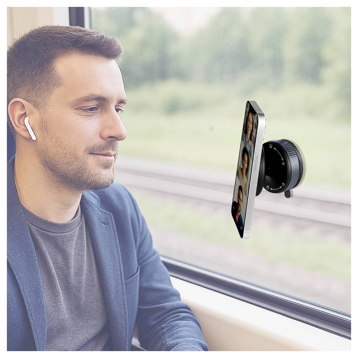 Muž s náuchy na uších v vlaku se dívá na smartphone připevněný na okně, pravděpodobně pro videohovor nebo sledování obsahu.
