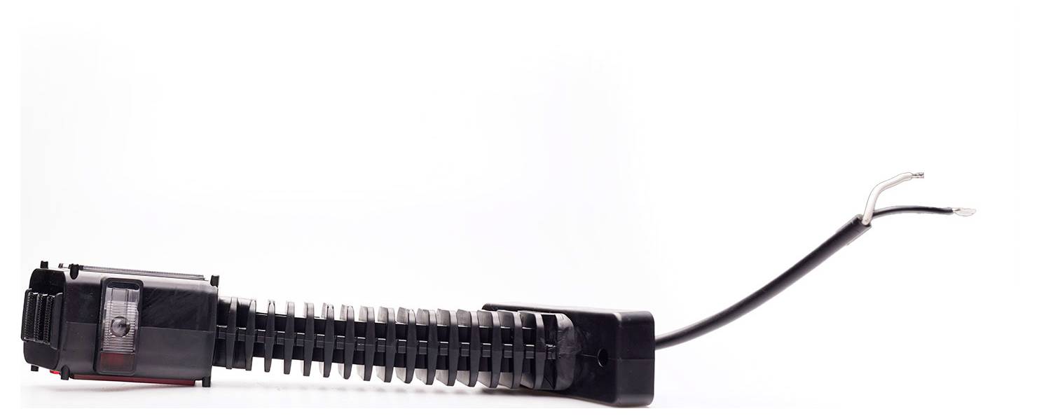 Detailní snímek černého izolovaného elektrického konektoru nebo kabelového svazku s exponovanými konci drátů na bílém pozadí.