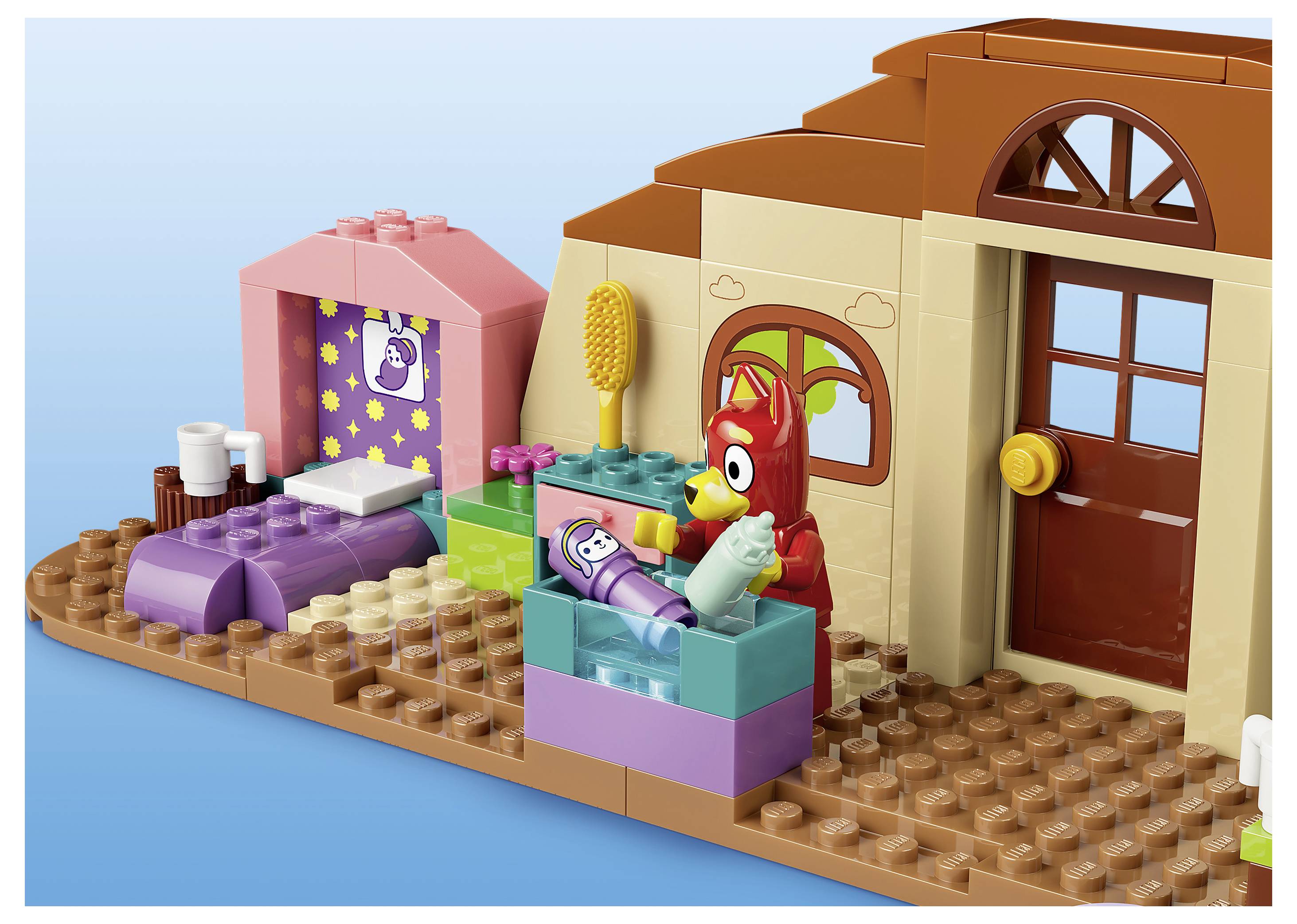 Ložnice ve stylu LEGO se červenou figurkou ptáka vedle postele, růžovou spací zónou a nátěrem hnědého domu s oknem a dveřmi.