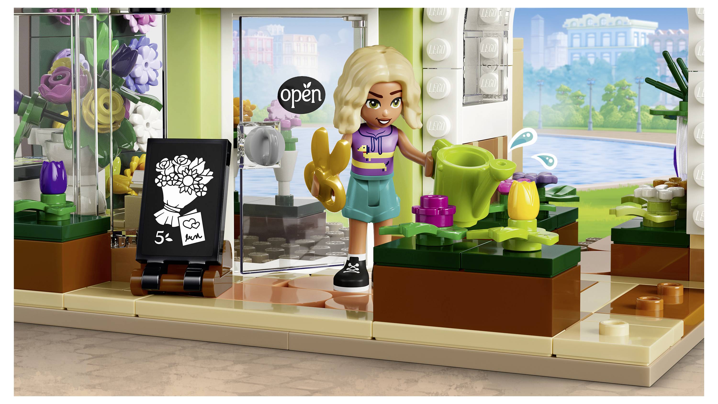 Interiér květinářství ve stylu LEGO s blondýnkou-minifigurkou, která si pohrává s květinami, cedulkou "otevřeno", pokojovými rostlinami v květináčích a jasným výhledem na bazén venku.