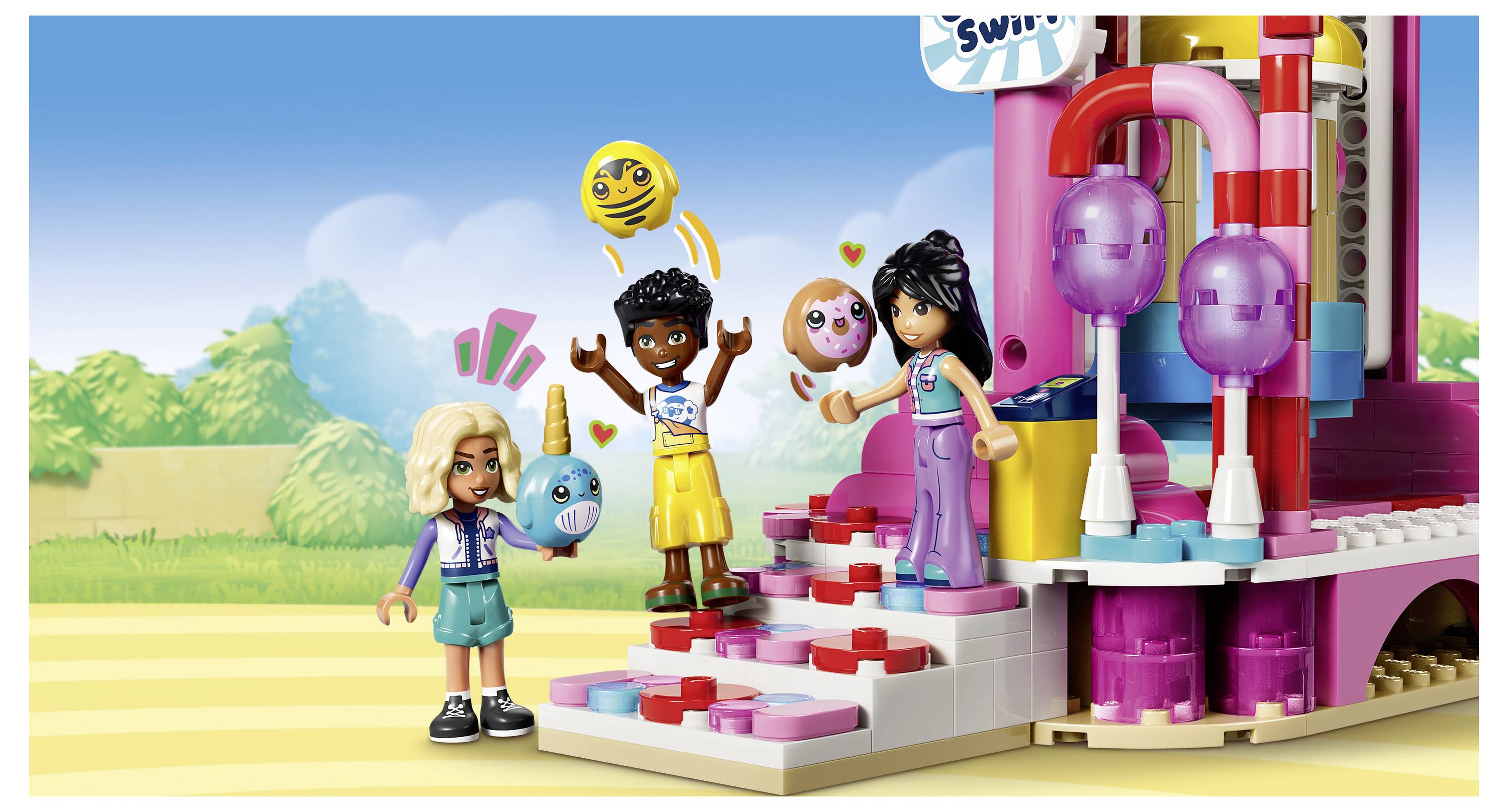 Tři postavičky ve stylu LEGO a dva domácí mazlíčci stojí na pastelově barevných schodech před jasně zbarvenou atrakí nebo stánkem zábavního parku.