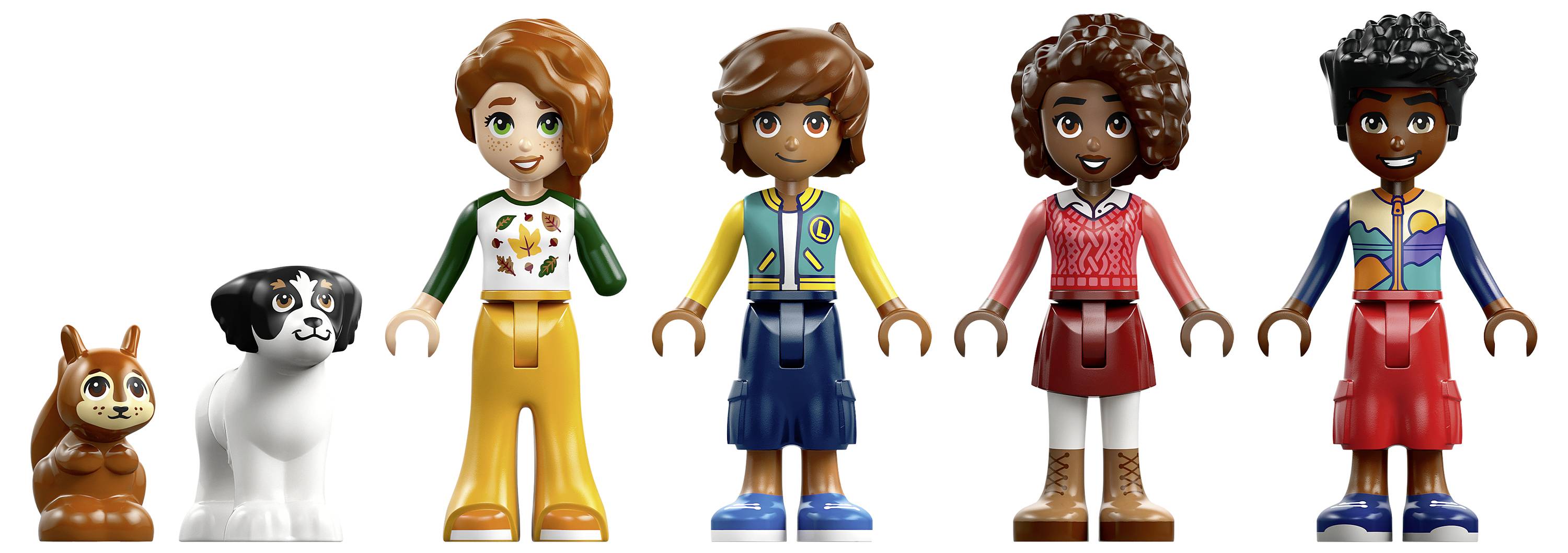 Tři LEGO přátelé se vozí na barevné horské dráze, zvedají ruce, když se vozy zakřivují skrze rychlou, jasně osvětlenou trať.