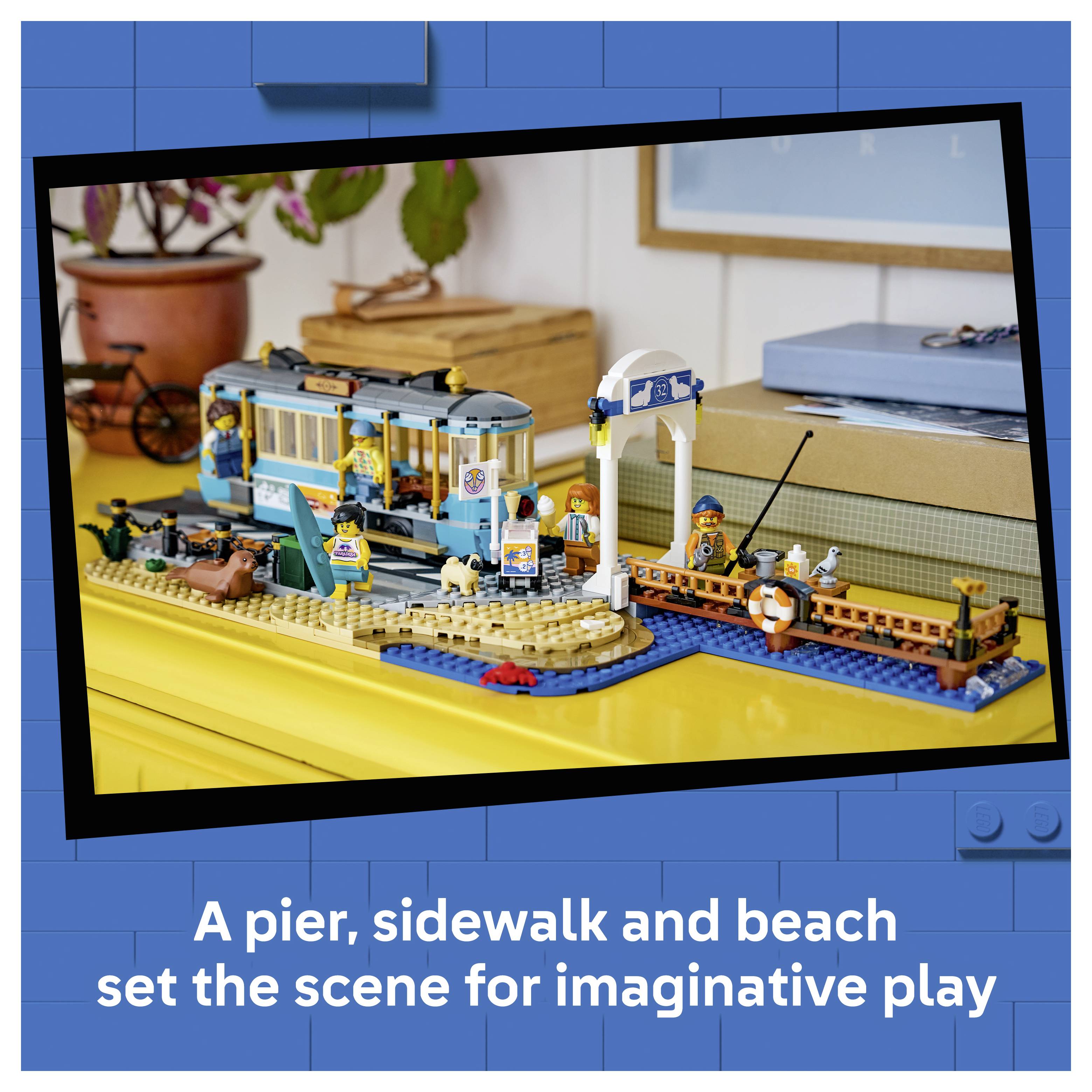 LEGO přímořská sada pro hru s molo, chodníkem, plážou, tramvají, přístavem a figurkami; nápis zní „Molo, chodník a pláž vytvářejí scénu pro tvůrčí hru"
