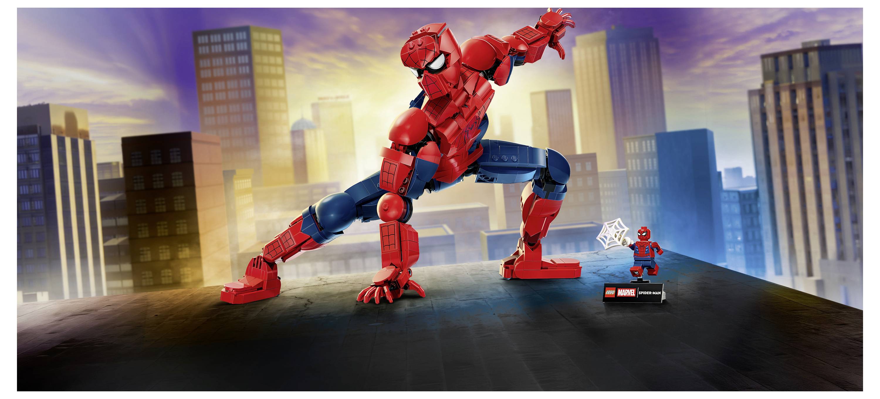 LEGO Spider-Man v chvíli napůl skrčeného akčního postoje nad střechou městské budovy, s malou figurkou Spider-Mana LEGO vystavené vpravo.