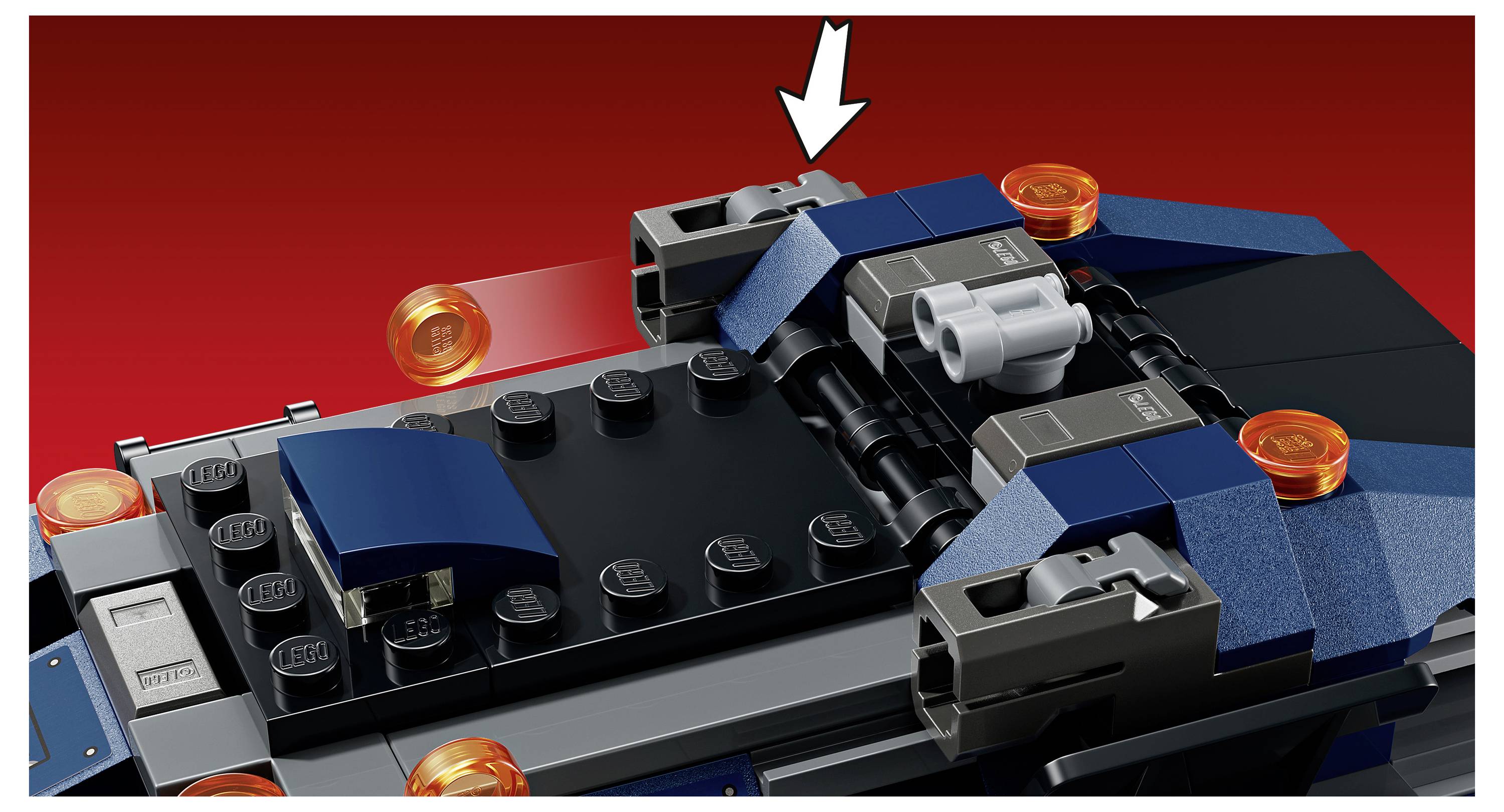 Zblízka model vesmírné lodi LEGO s bílou šipkou ukazující na šedý horní konektor na střeše lodi.