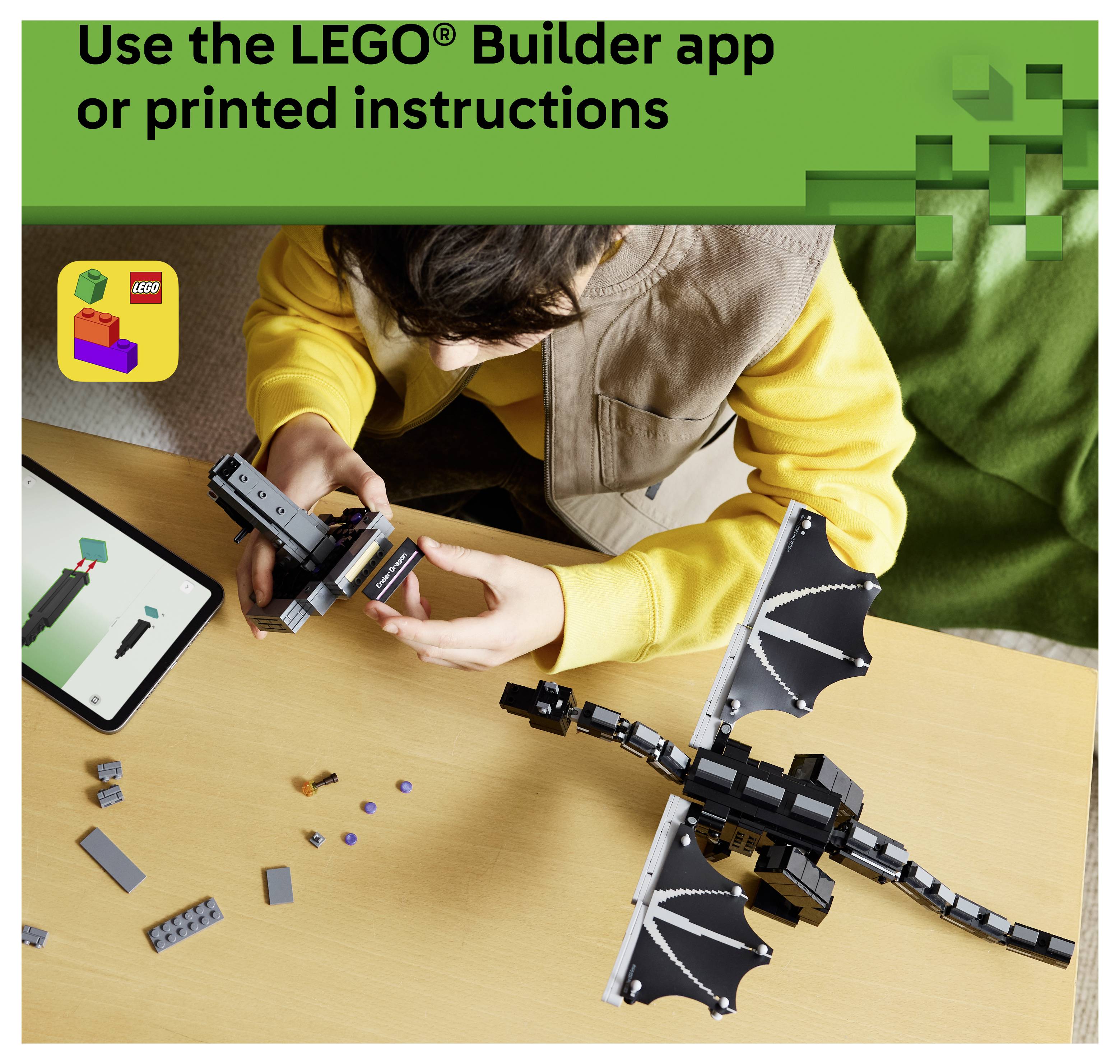Osoba stavující LEGO draka s využitím aplikace LEGO Builder nebo tištěných instrukcí; tablet zobrazuje kroky montáže vedle rozptýlených kostek.
