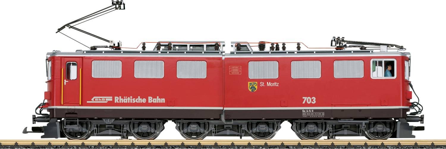 Červená elektrická lokomotiva číslo 703 s nápisem „Rhatische Bahn" a „St. Moritz" na boku, zobrazena v profilu na kolejích.