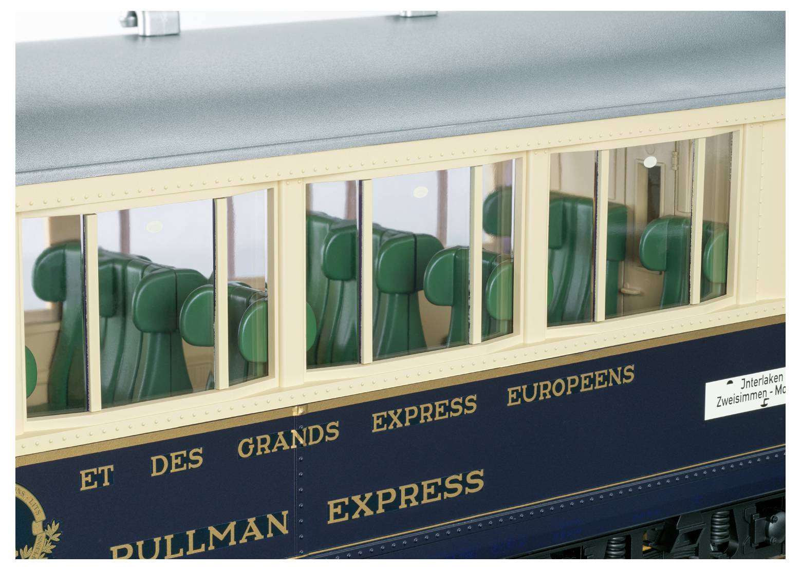 Model expresního železničního vozu Pullman se zelenými sedadly viditelnými skrz okna a textem "PULLMAN EXPRESS" a "DES GRANDS EXPRESS EUROPEENS" na straně.