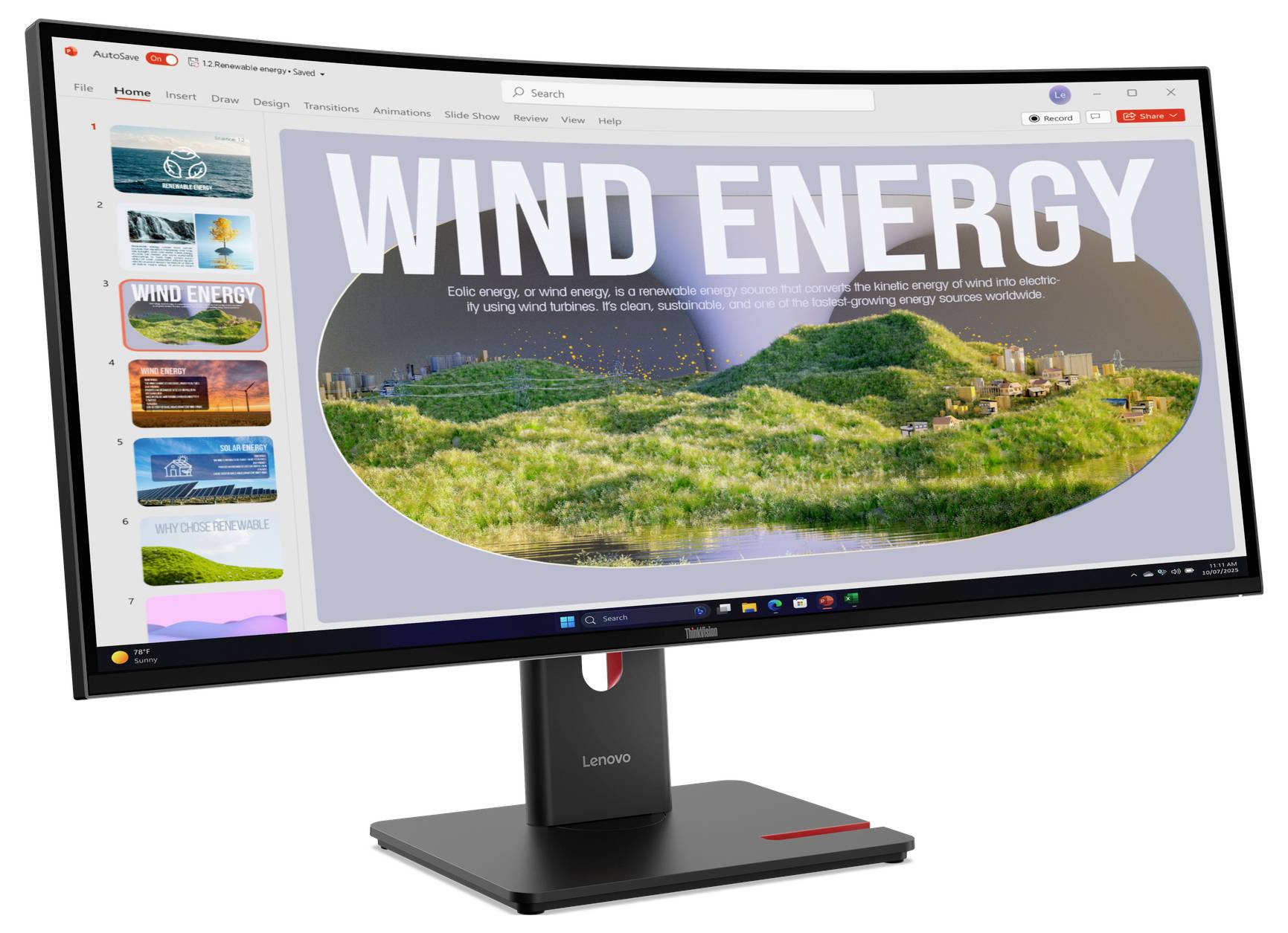 Prezentační snímek na monitoru s názvem "VĚTRNÁ ENERGIE" zobrazující krajinu s větrných turbínami a zeleným kopcem.