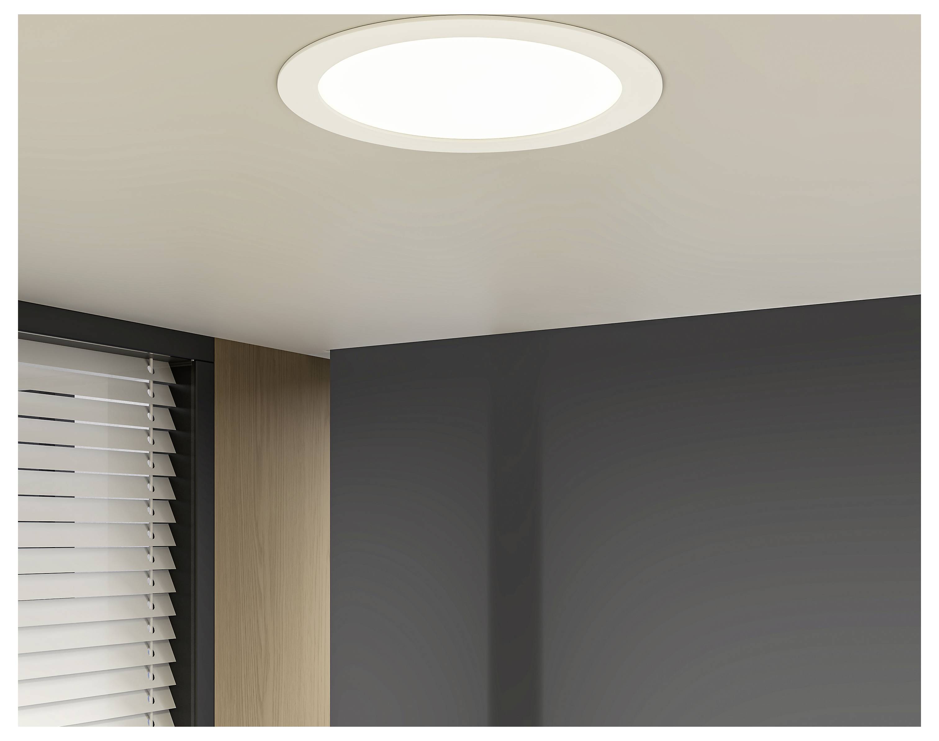 Stropní kulatá přisazená lampa v rohu moderní místnosti nad tmavě šedou stěnou a žaluziemi u okna.