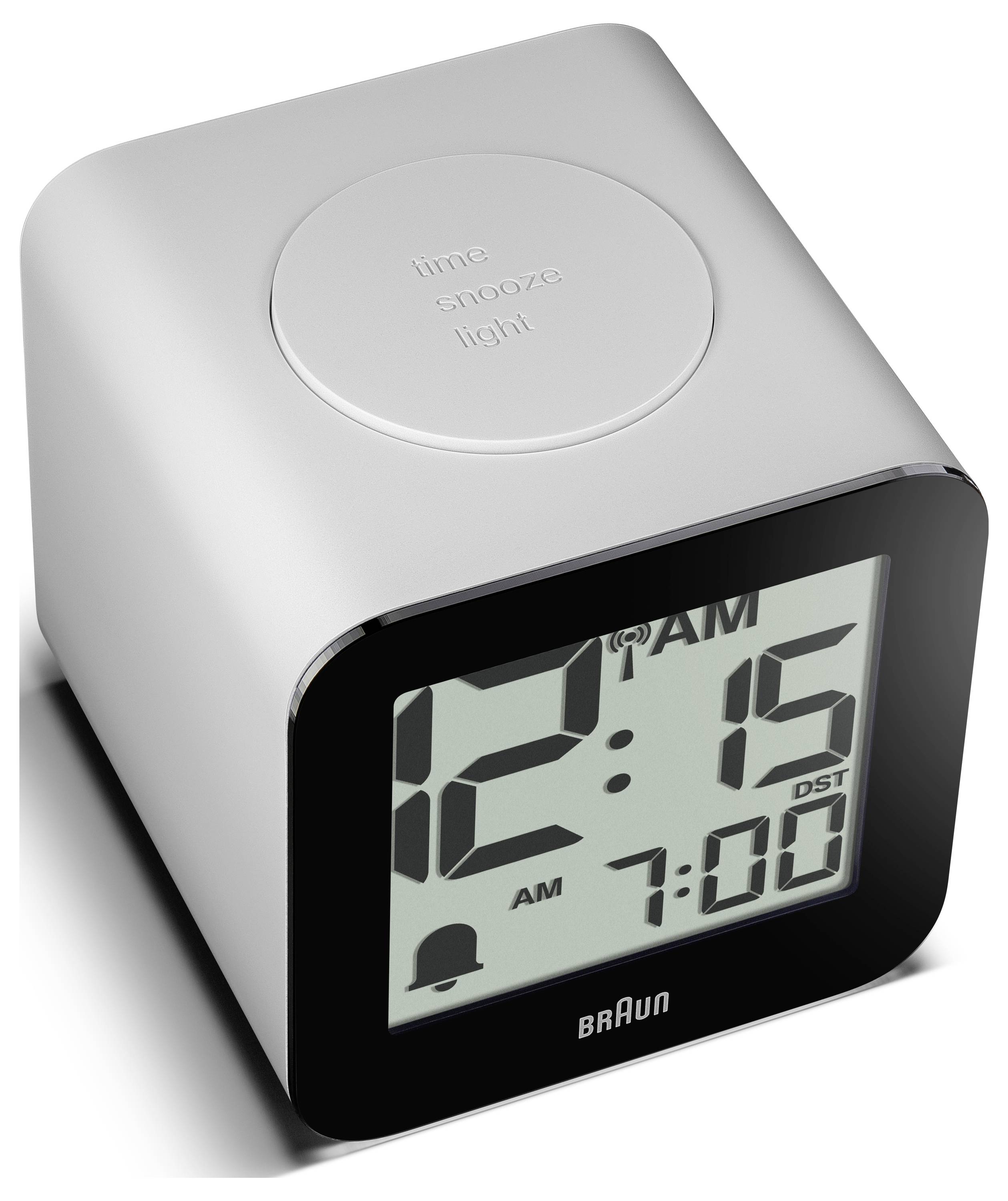 Moderní digitální budík Braun ukazující 12:15 v noci a budík nastavený na 7:00, s tlačítkem spánkového světla nahoře.