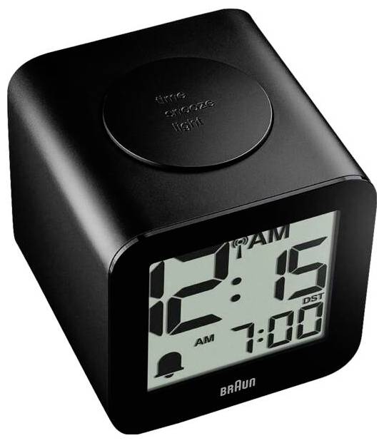 Černé digitální budík Braun zobrazující 12:15 AM s indikátorem budíku na 7:00 a tlačítkem odložení/světla na vrcholu.