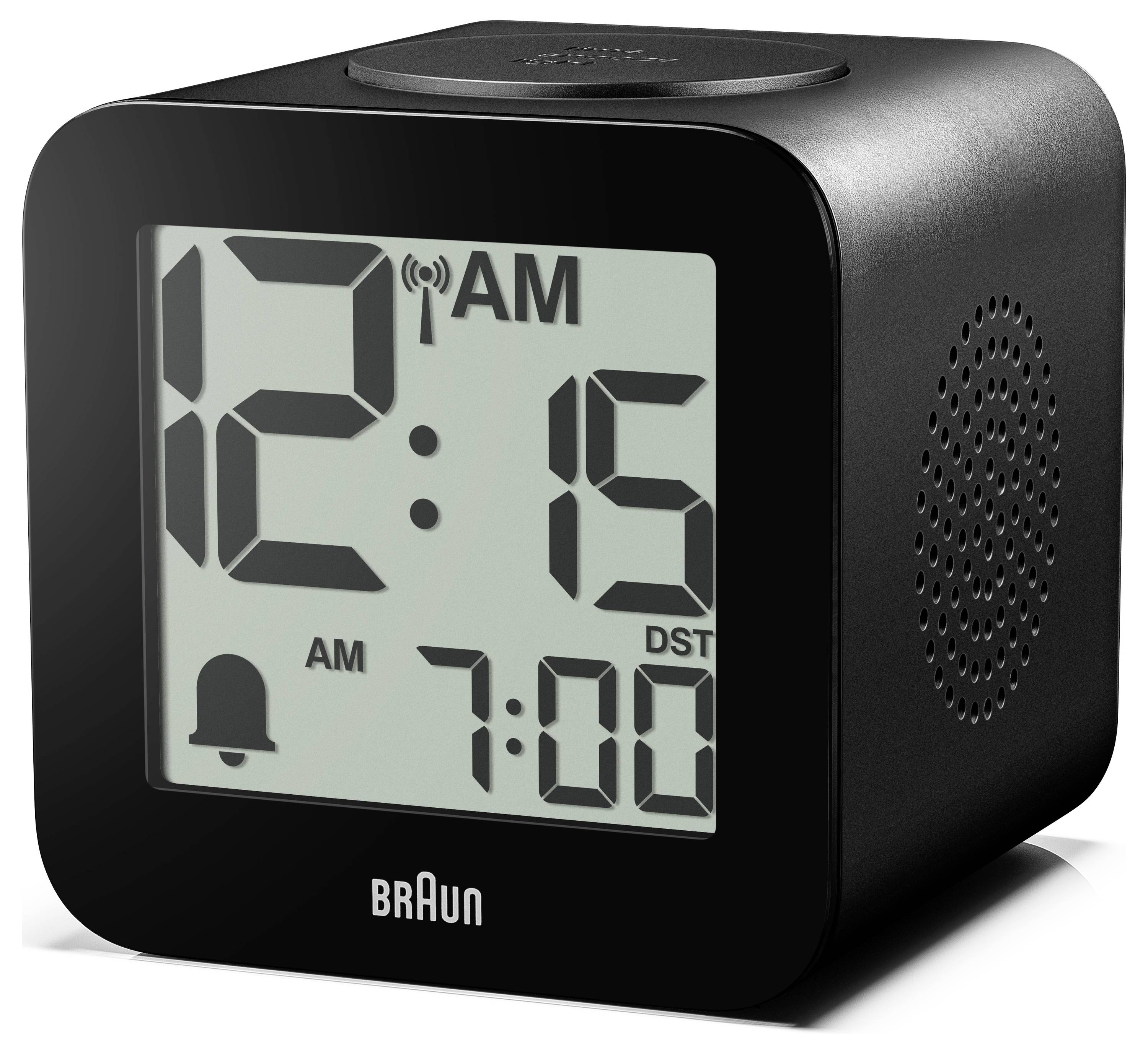 Černé digitální budíky Braun zobrazující 12:15 v noci, se symboly alarmu a letního času a nastavením 7:00 na displeji.