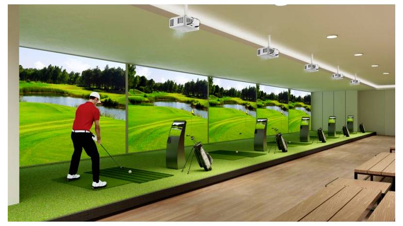 Krytá golfová odpaliště s golfistou v červeném oblečení trénujícím na odpališti orientovaném na velké obrazovky simulující golfový kurt.