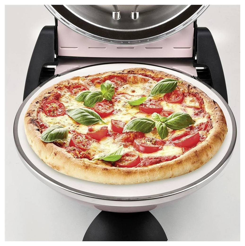 Čerstvá pizza s bazalkou a rajčetem na kulatém kameني peci uvnitř otevřené pracovní desky pizzy.