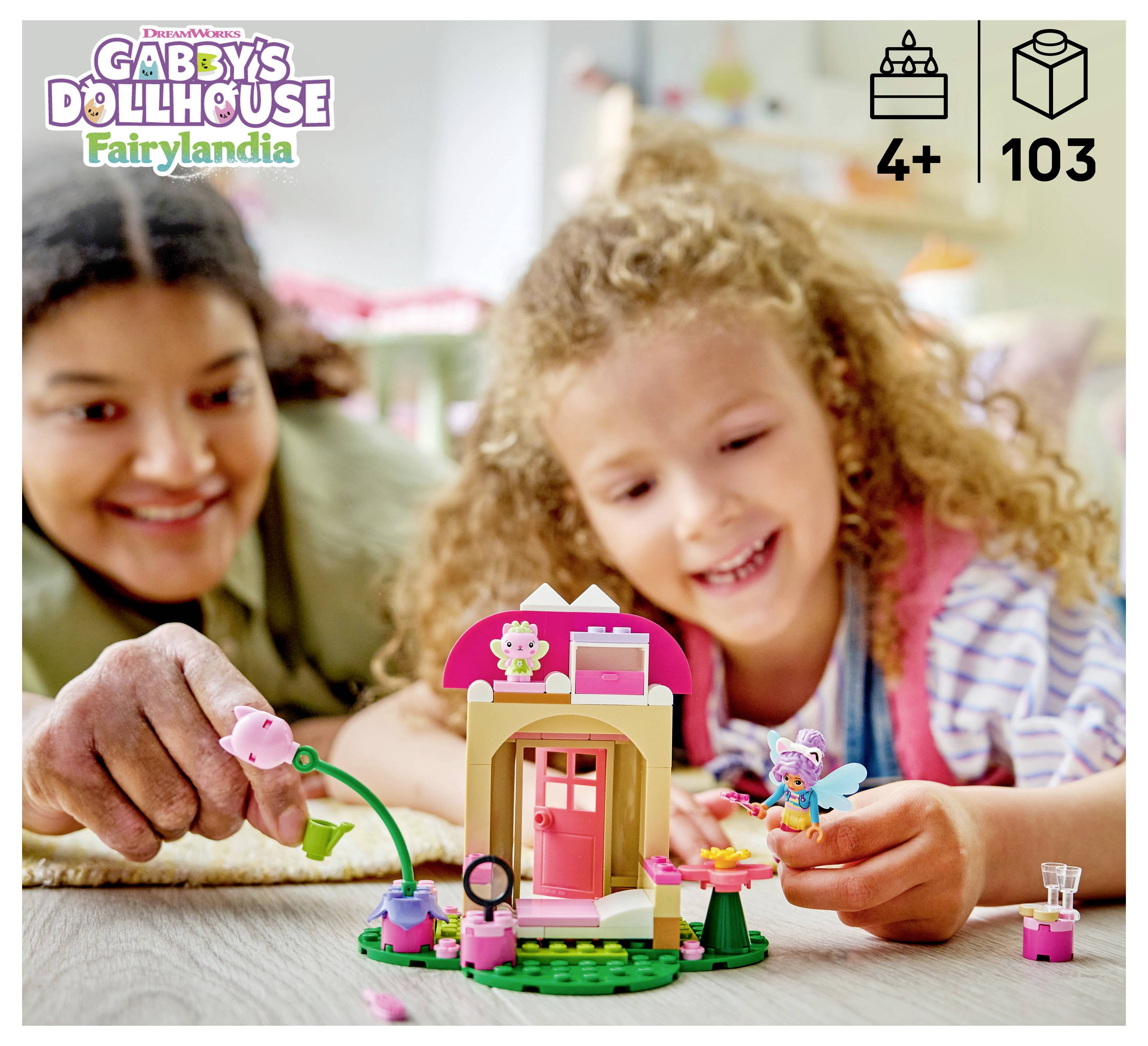 Dítě a dospělý se smějící si při hraní se stavebnicí LEGO Gabby's Dollhouse Fairylandia, která zobrazuje malý dům víly a mini figurky; věk 4+, 103 dílů.