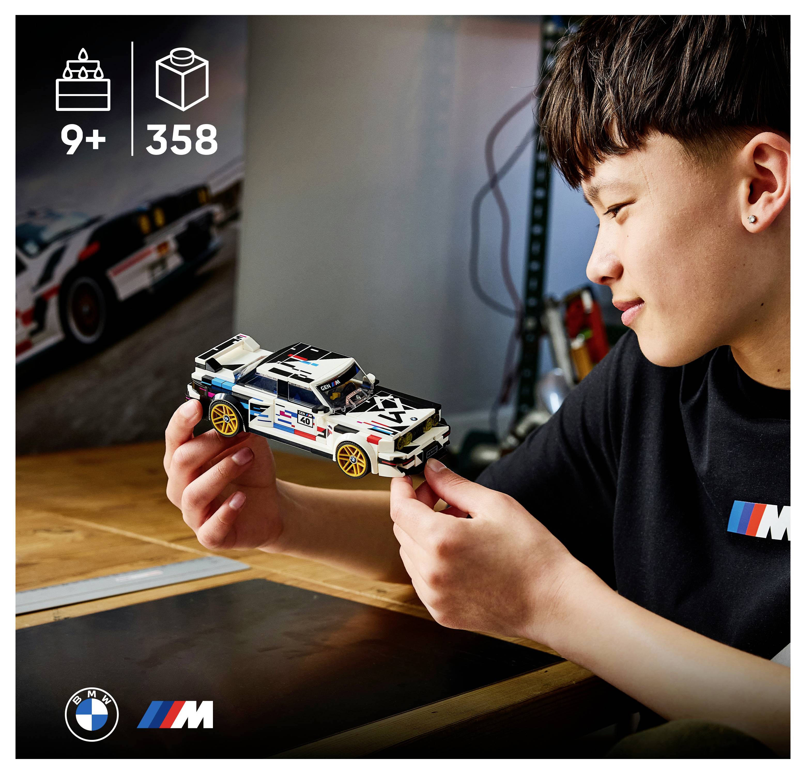 Chlapec držící a obdivující model závodního auta LEGO BMW M; obrázek ukazuje hodnocení 9+ let a 358 dílů.