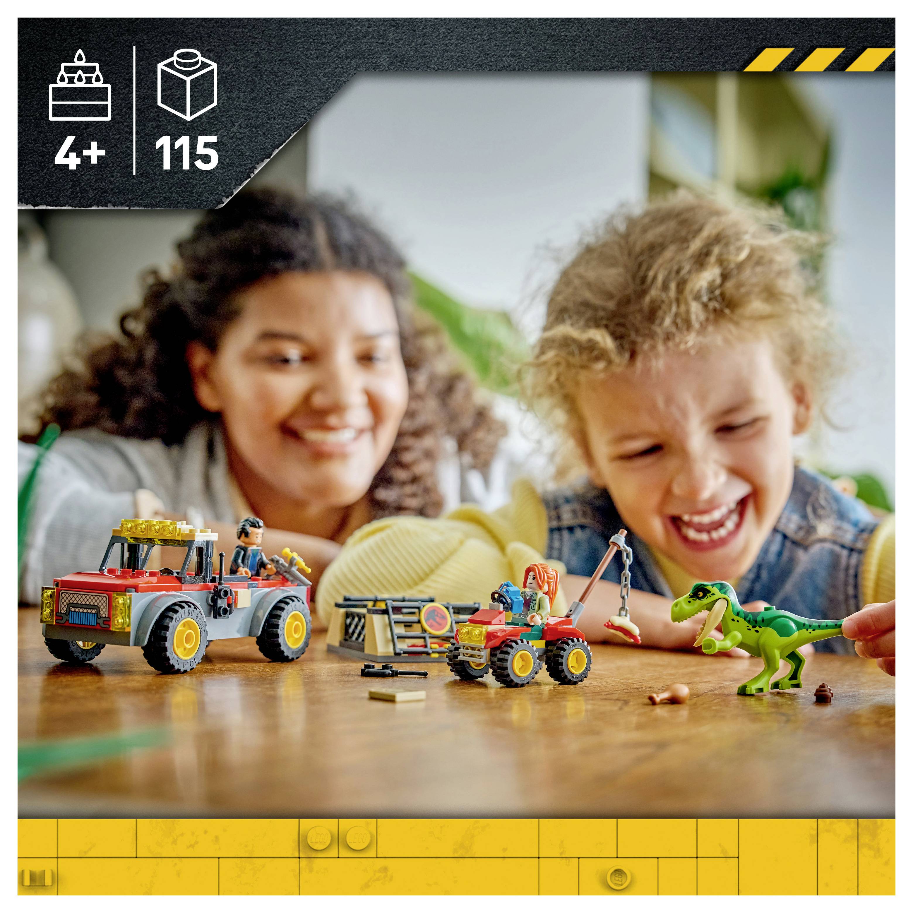 Dvě děti si hrají s vozidly podobnými LEGO a zeleným dinosaurem na stole, přičemž v rohu je uvedena věková kategorie 4+ a 115 kusů.